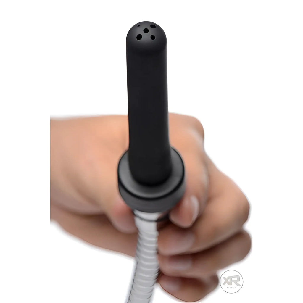 CleanStream Travel Enema adapter: A hand holding a black, cylindrical nozzle with a perforated tip and metal hose.