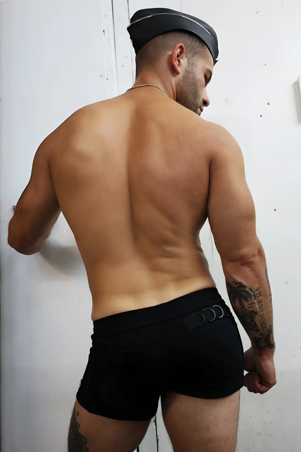 Black cockpit shorts with a sleek fitted design and three circular metal accents on the waistband