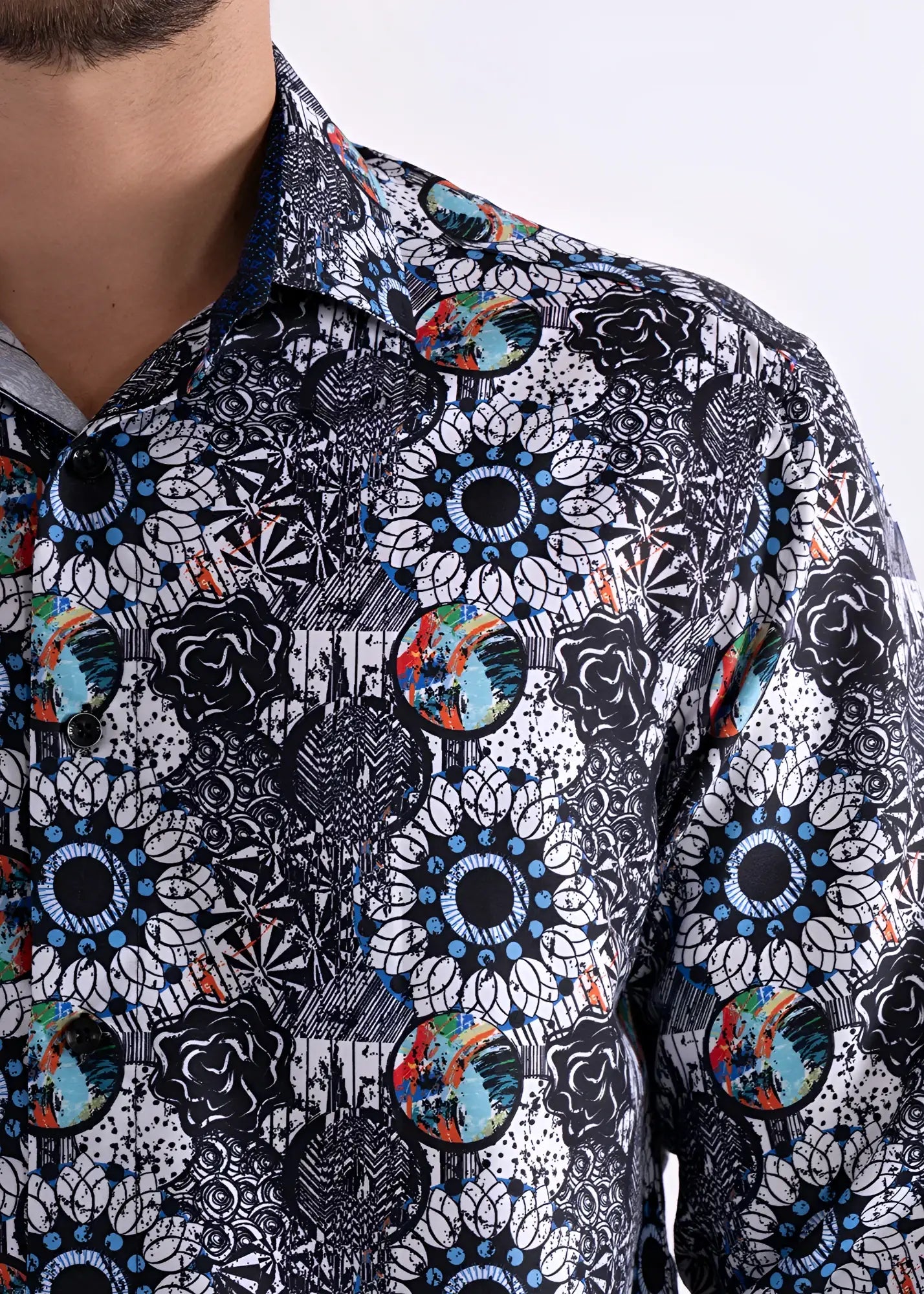 A men’s long sleeve button-up shirt with bold black and white floral pattern and colorful blue green orange red accents