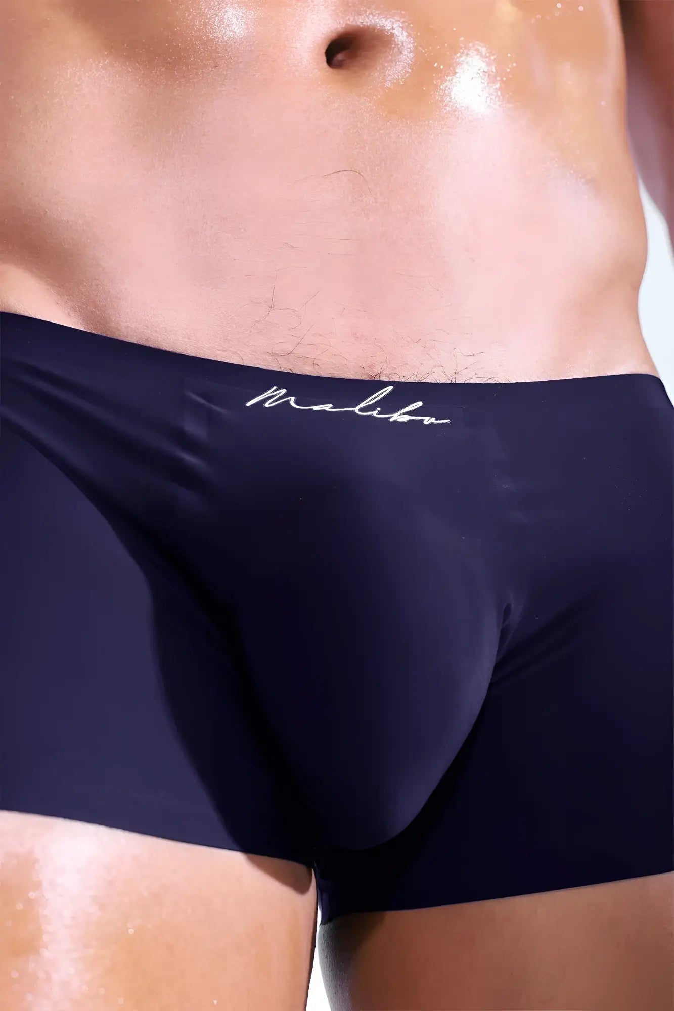 Dark navy blue silky seamless malibu brand boxer briefs with subtle white cursive logo on waistband indigo navy