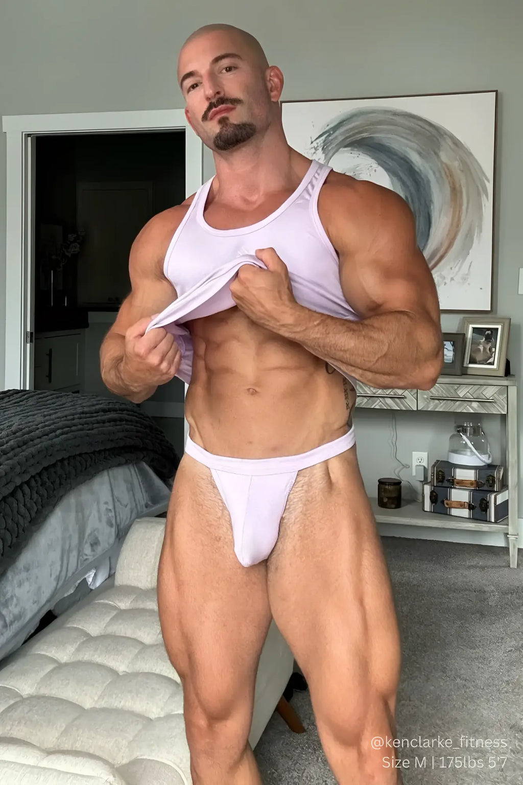 A man wearing a lavender comfy everyday ribbed thong for men paired with a white form-fitting tank top