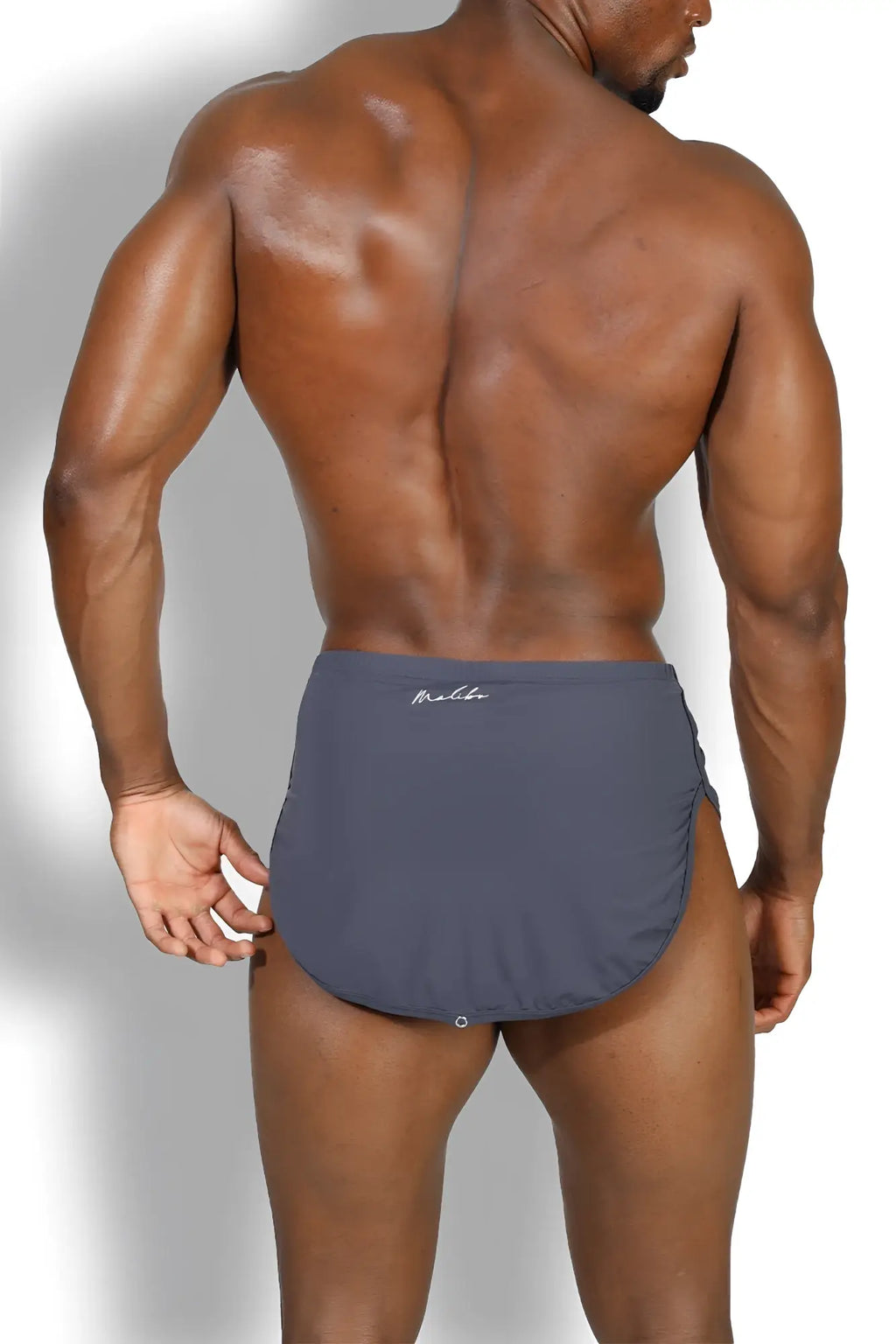 Dark gray sleek form-fitting swim trunks with subtle molde logo on waistband in cool-dri 2-in-1 shorts with thong lining