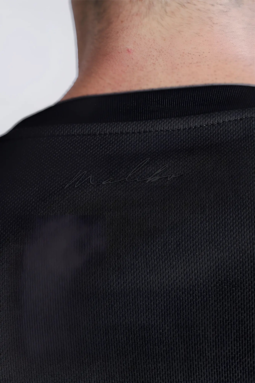 Back view of black cool-dry oversized relaxed crop top with textured fabric and subtle malibu logo embroidery