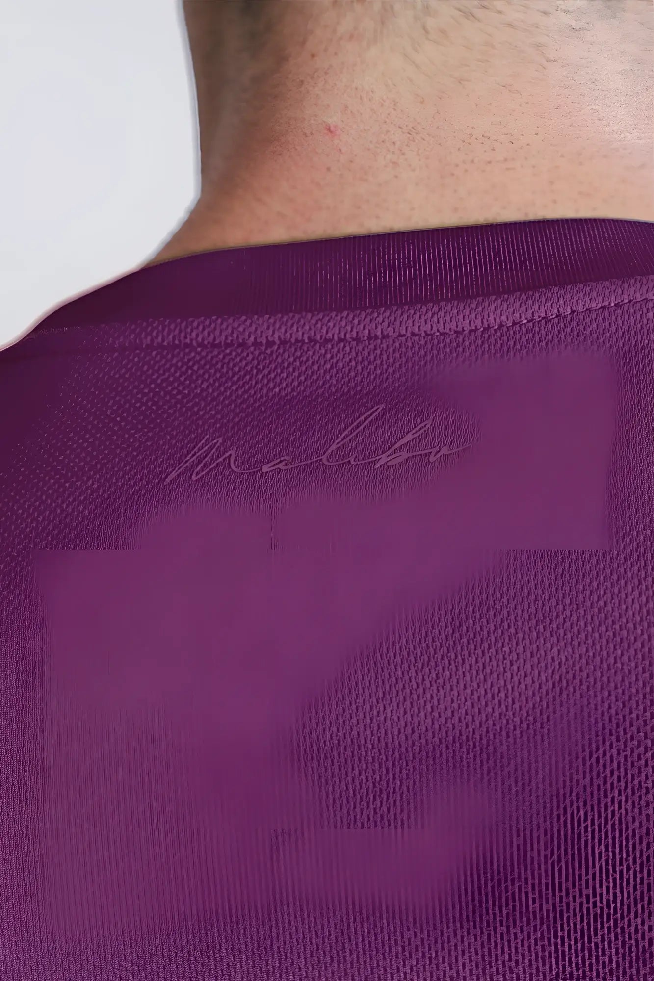 Back view of cool-dry oversized relaxed crop top in plum purple textured fabric with subtle embroidered brand logo