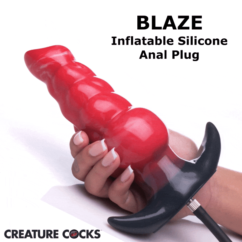 Creature Cocks Blaze inflatable silicone anal plug in bright red, held in a hand, featuring a black base and air tube.