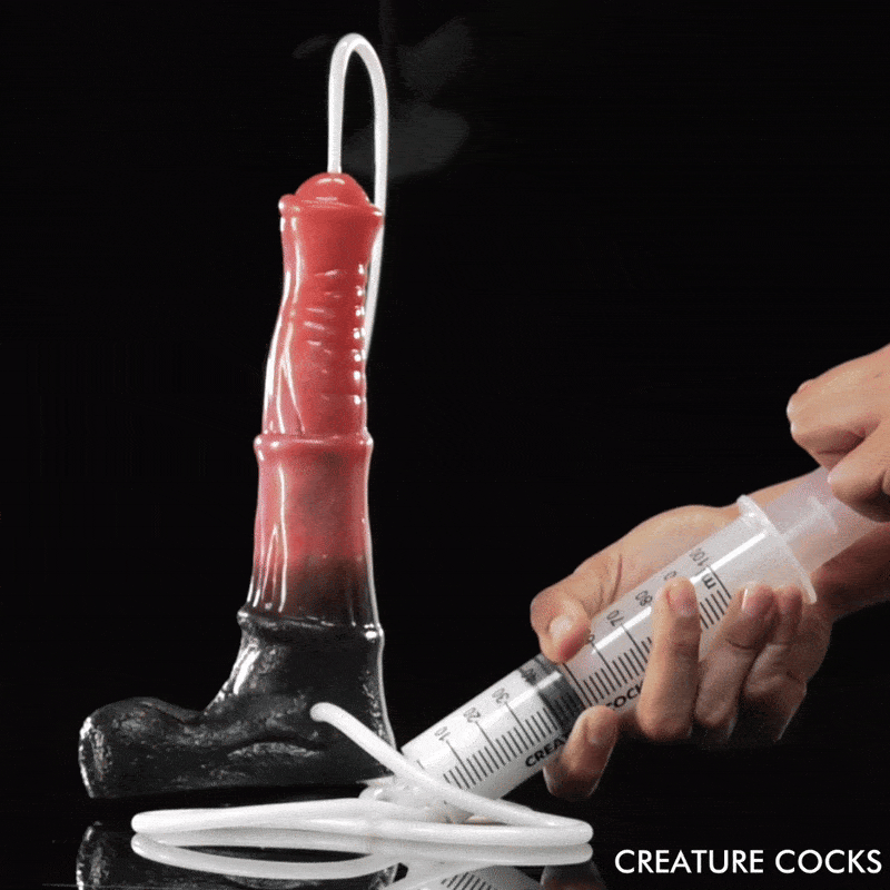 Creature Cocks Centaur squirting dildo in red and black, connected by tubing to a hand-held fluid-injection syringe.