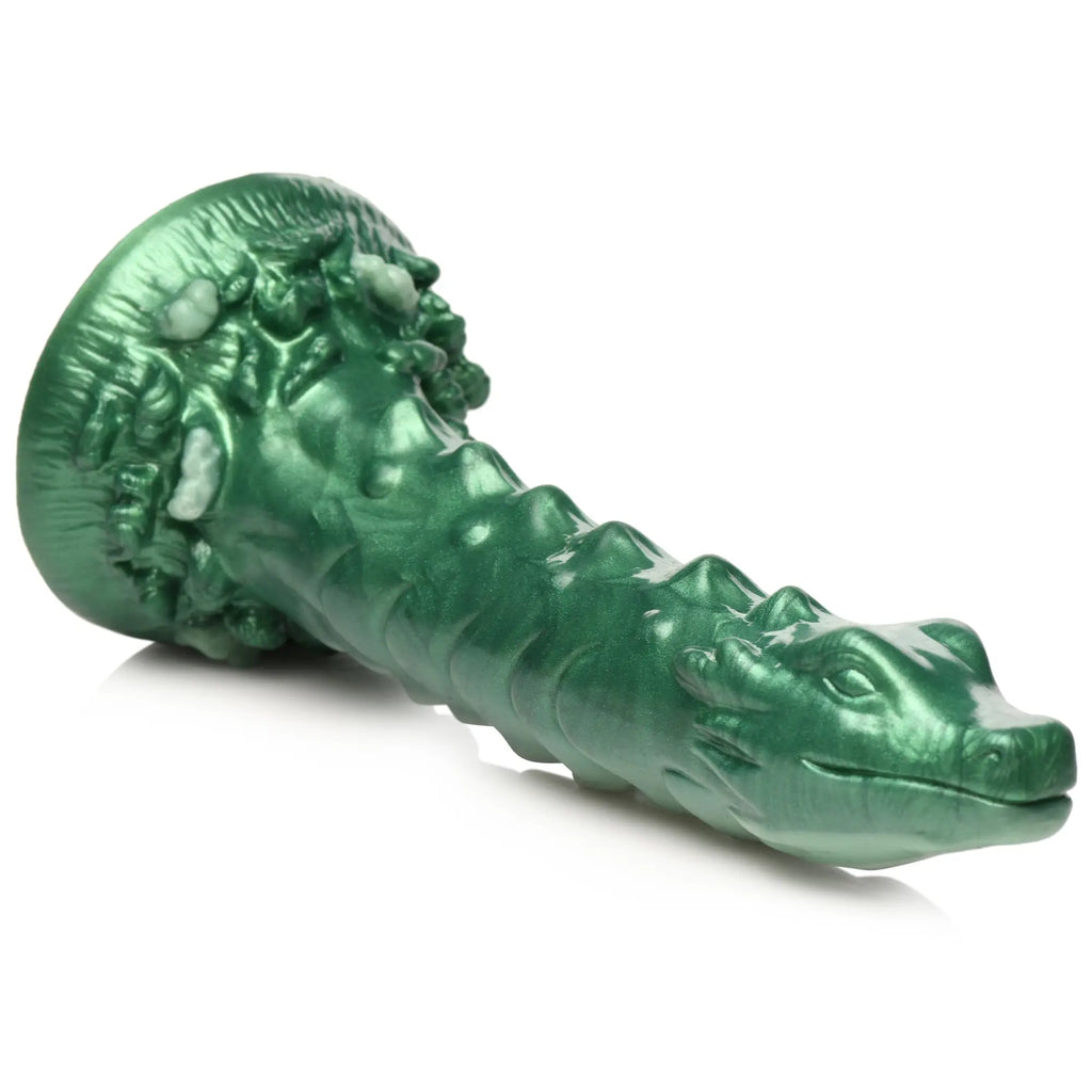 Creature Cocks Cockness Monster silicone dildo in metallic green, featuring a sculpted creature head and spine details.