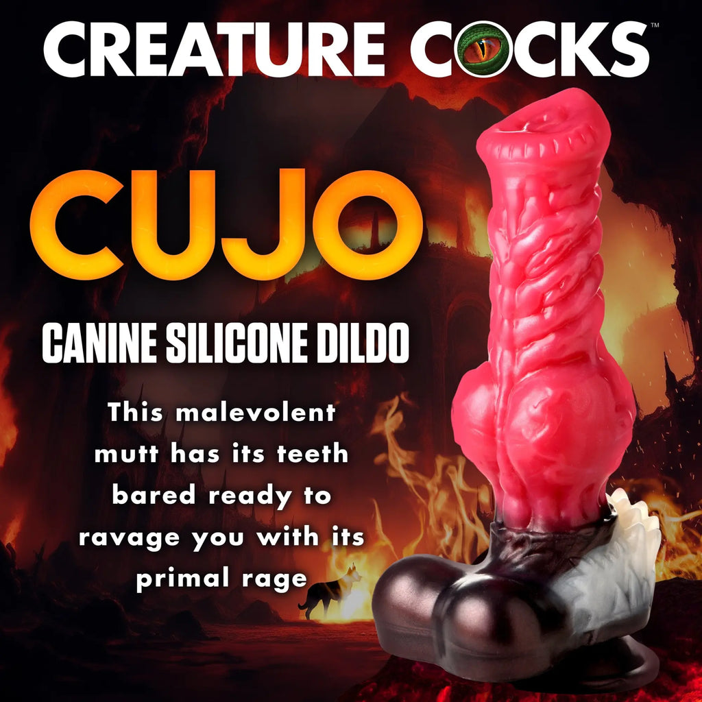 Creature Cocks Cujo silicone dildo featuring a textured pink shaft, prominent base, and fiery, dark background graphics.