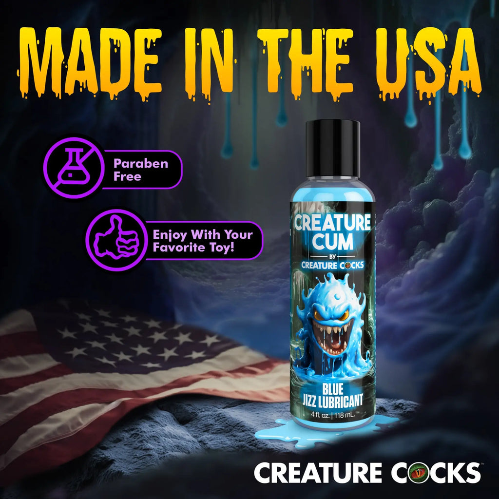 A 4oz bottle of blue lubricant with a monster graphic, placed on a surface with an American flag background.