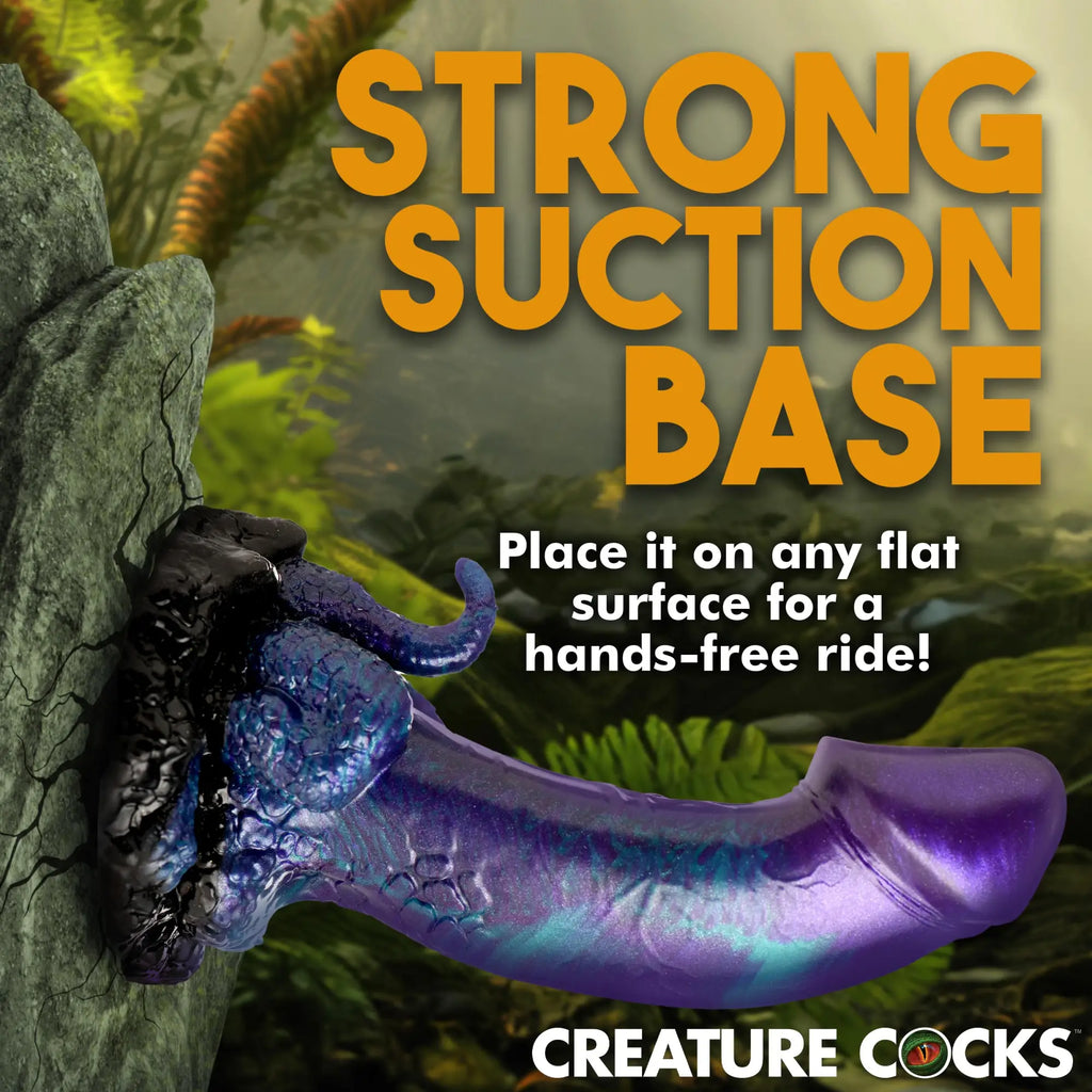 Creature Cocks Dino-Dick: A metallic purple and black, textured silicone dildo with a suction base on a rock background.