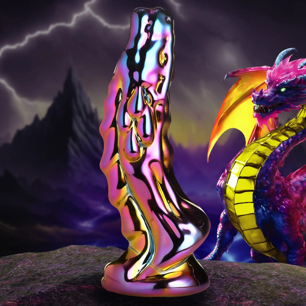 Creature Cocks Dragon Glass dildo with a metallic, iridescent finish, displayed before a fantasy dragon backdrop.