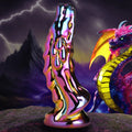 Creature Cocks Dragon Glass dildo with a metallic, iridescent finish, displayed before a fantasy dragon backdrop.