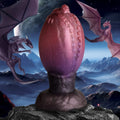 Creature Cocks Dragon Hatch silicone egg in a purple-to-black gradient with sparkles, set against a fantasy landscape.
