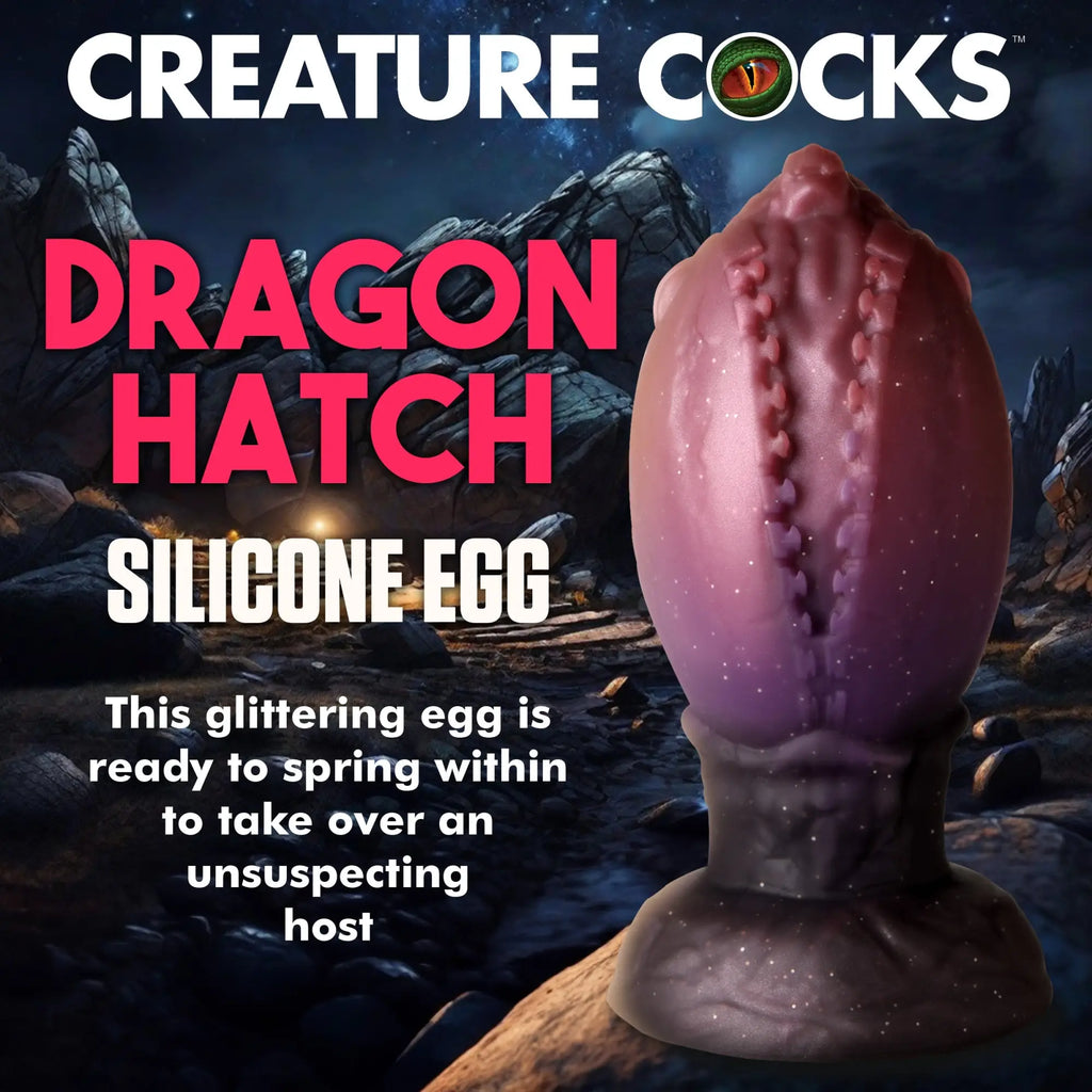 Creature Cocks Dragon Hatch: A glittering purple, textured silicone egg toy on a sturdy base against a rocky background.