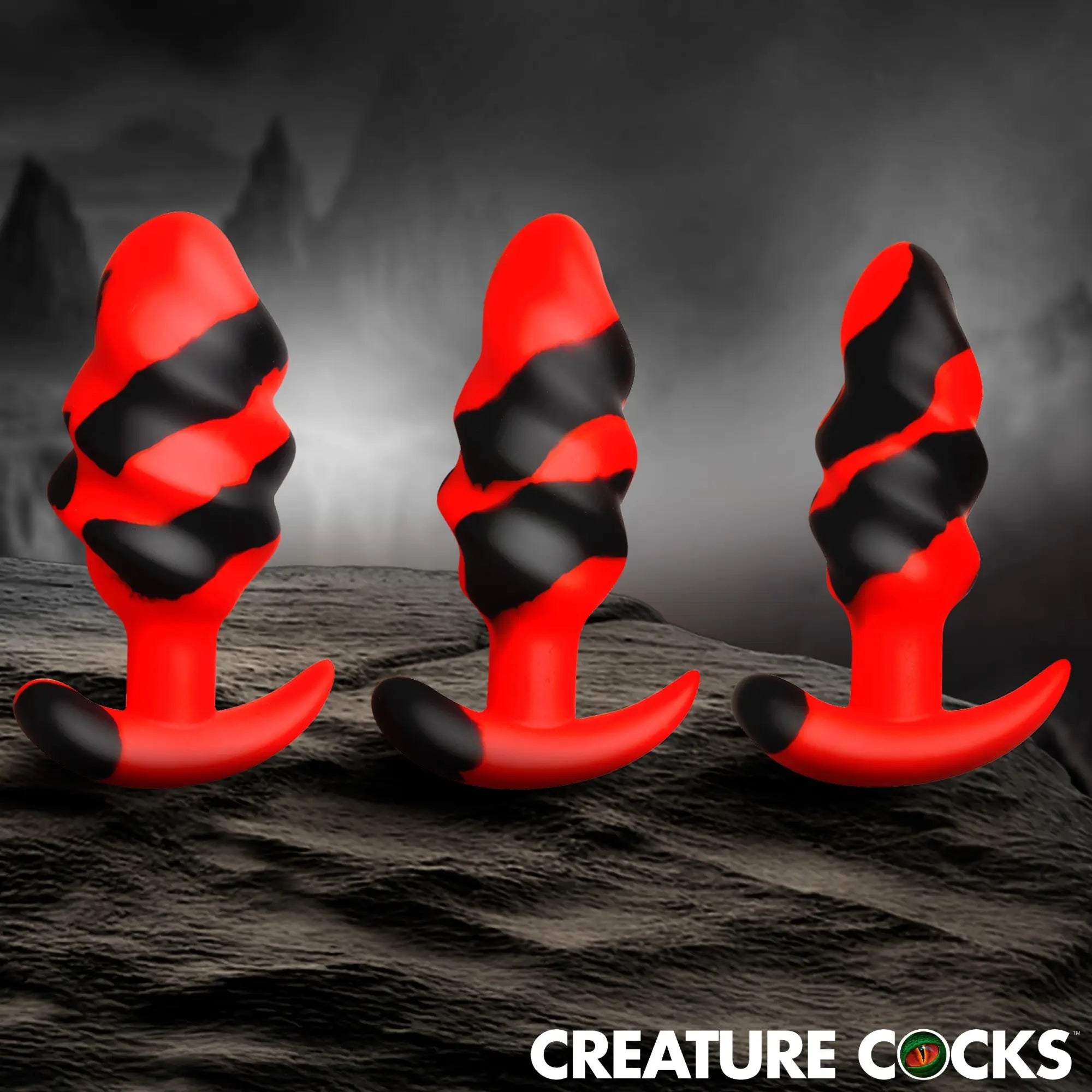 Creature Cocks Dragon Trainer set: three red and black swirled silicone butt plugs with textured, ridged shafts.
