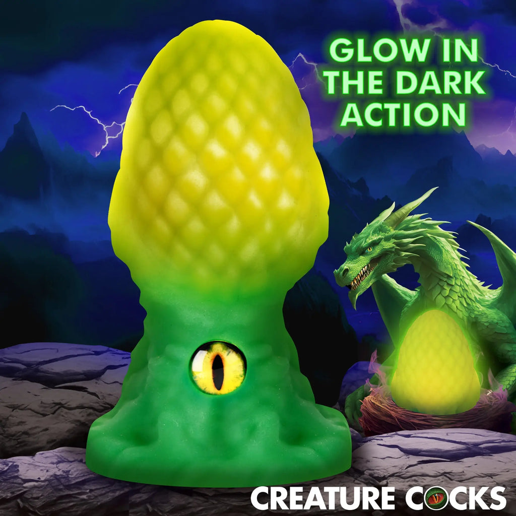 Creature Cocks Eye of the Dragon silicone butt plug: a green, textured, scale-patterned toy with a yellow dragon eye.