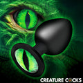 Creature Cocks Creature Eye butt plug: A matte black silicone plug with a bright green reptilian eye on the base.