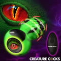 Creature Cocks Eye of the Spawn vibrating green and black silicone butt plug with a remote against a monster background.