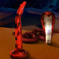 Creature Cocks Giant King Cobra silicone dildo in red with black markings, shown against a desert and starry night sky.