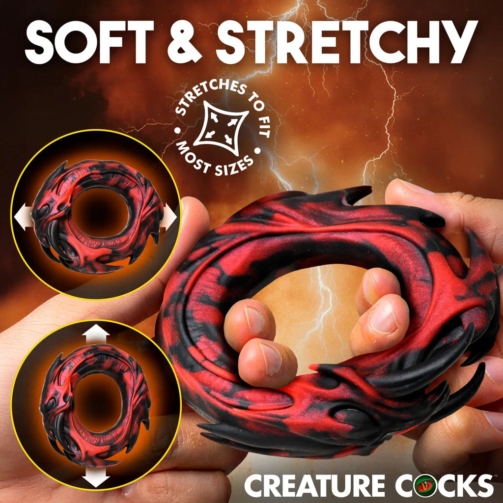 Creature Cocks Hell Fang silicone cock ring: a flexible, black and red monster-themed ring being stretched by hands.