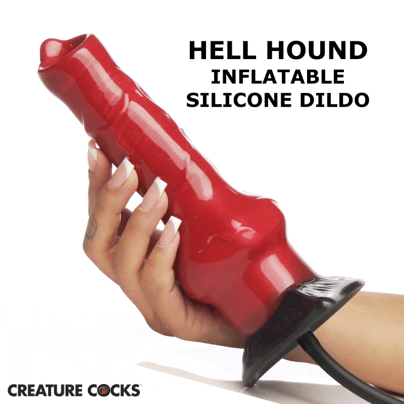 A hand holds a red, textured Creature Cocks Hell Hound inflatable silicone dildo with a black base and inflation tube.