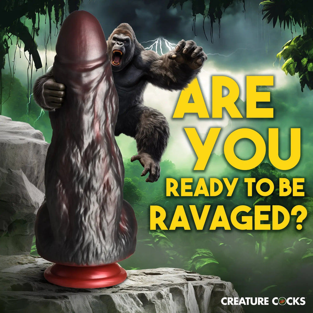 Creature Cocks King Kong dark brown textured silicone dildo with red base, featured in a jungle scene with a gorilla.