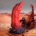 Creature Cocks King Scorpion silicone dildo in red and black, shaped like a scorpion in a desert landscape.
