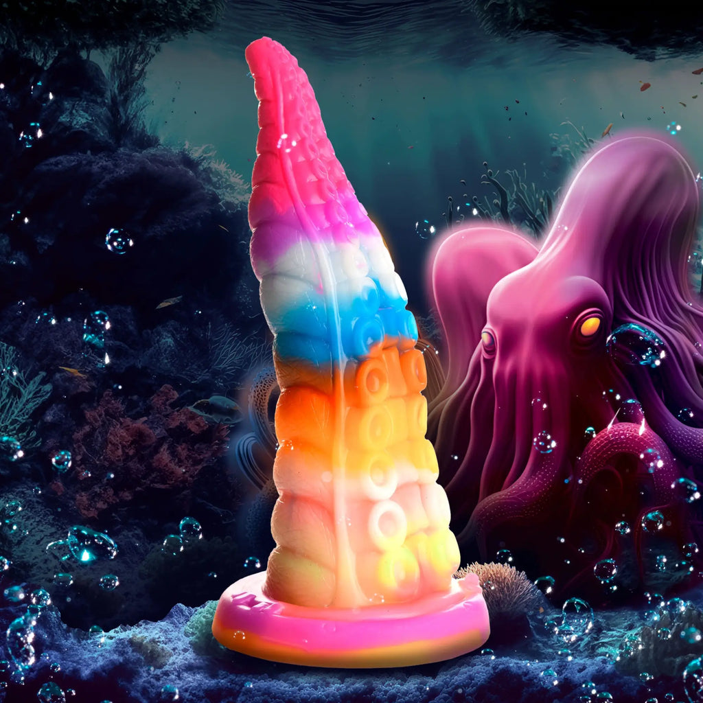 Creature Cocks Luminoctopus glow-in-the-dark silicone tentacle dildo in a vibrant rainbow gradient under the sea.