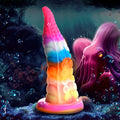 Creature Cocks Luminoctopus glow-in-the-dark silicone tentacle dildo in a vibrant rainbow gradient under the sea.
