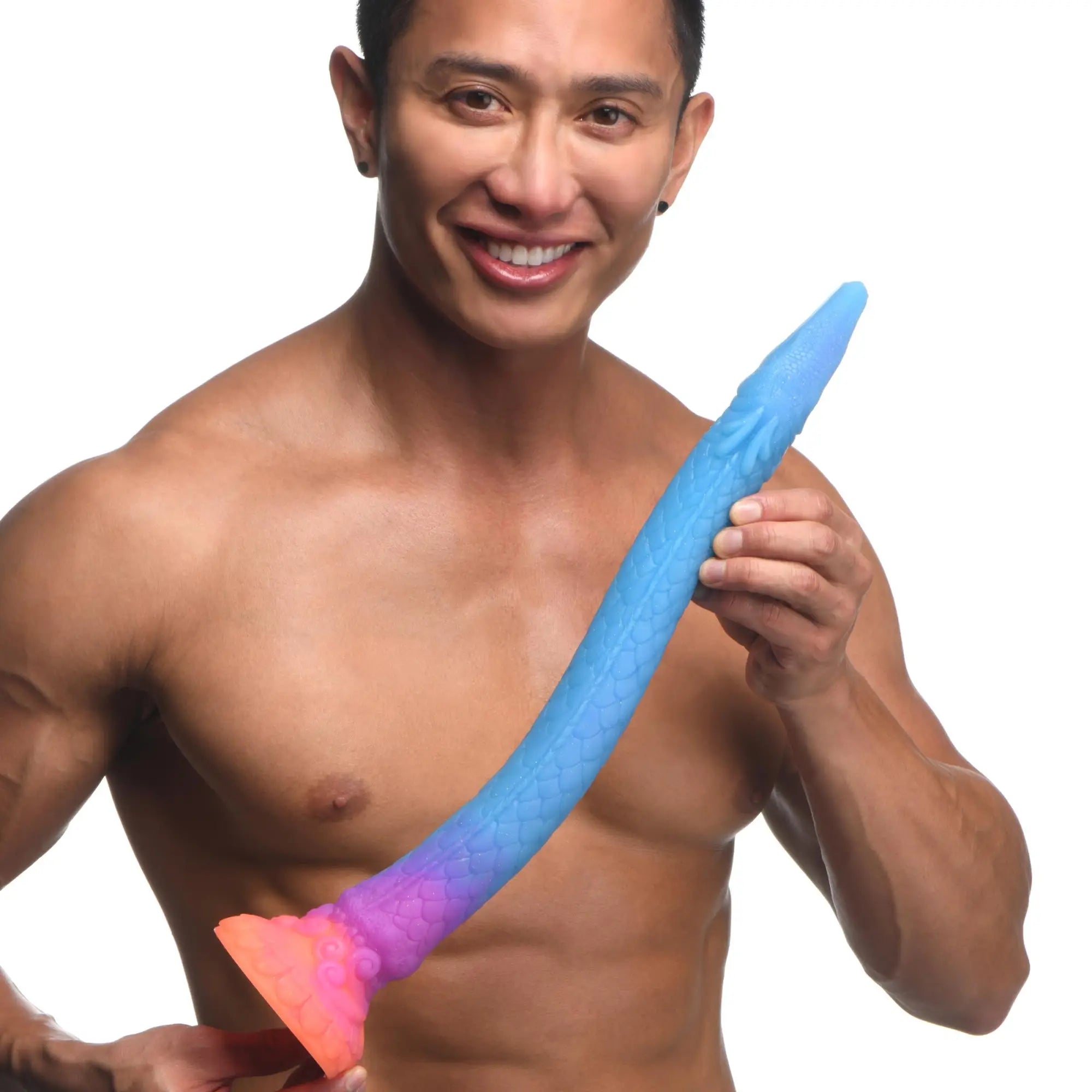 Smiling man holding a blue-to-purple gradient, textured Creature Cocks Makara snake dildo with an orange suction base.