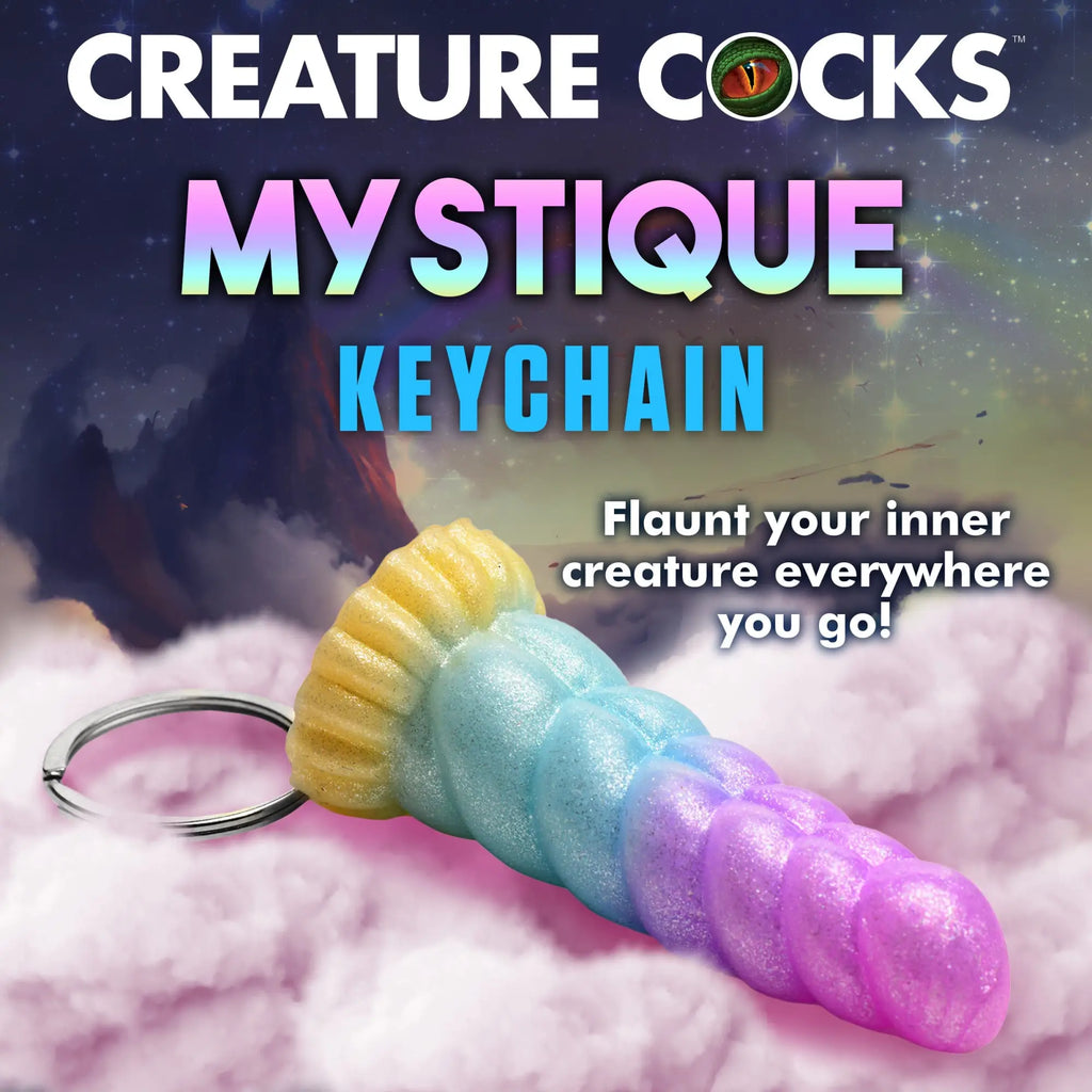 Creature Cocks Mystique mini dildo keychain in a glittery, gradient yellow, blue, and purple texture on pink clouds.
