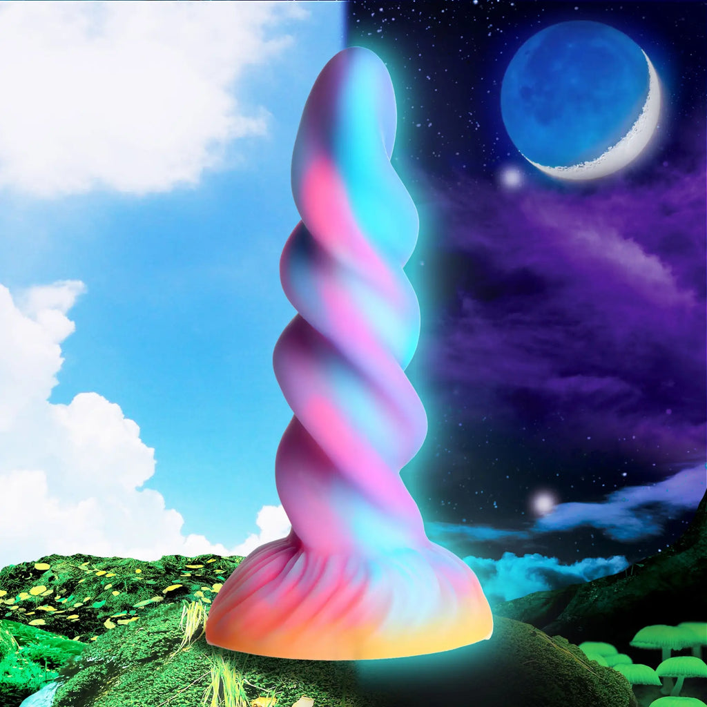 Creature Cocks Moon Rider glow-in-the-dark unicorn dildo: a pink and blue spiral-textured toy against a day-night background.