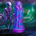 Creature Cocks Octophallus dildo in marbled purple and blue silicone, featuring tentacle textures, on a rocky shore.