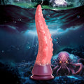Creature Cocks Octoprobe: a pink, tentacle-shaped silicone dildo with suction base set against a dark underwater scene.