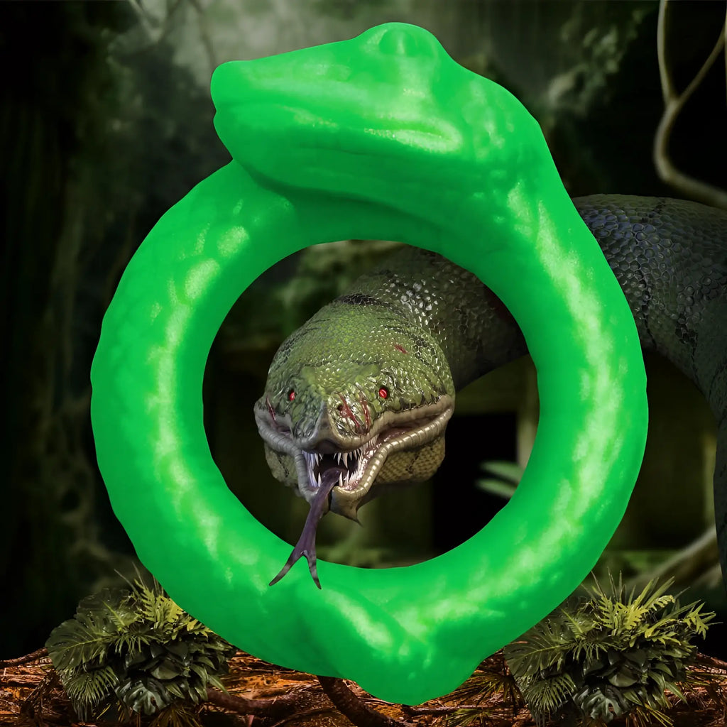 Creature Cocks Serpentine silicone cock ring in bright green, shaped like a coiled snake, against a jungle background.