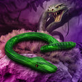 Creature Cocks Slither: A bright green, textured, snake-shaped silicone dildo resting on a rock in a jungle.