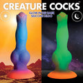 Creature Cocks Space dildo: a blue-to-pink silicone alien toy shown in daylight and glowing green in the dark.