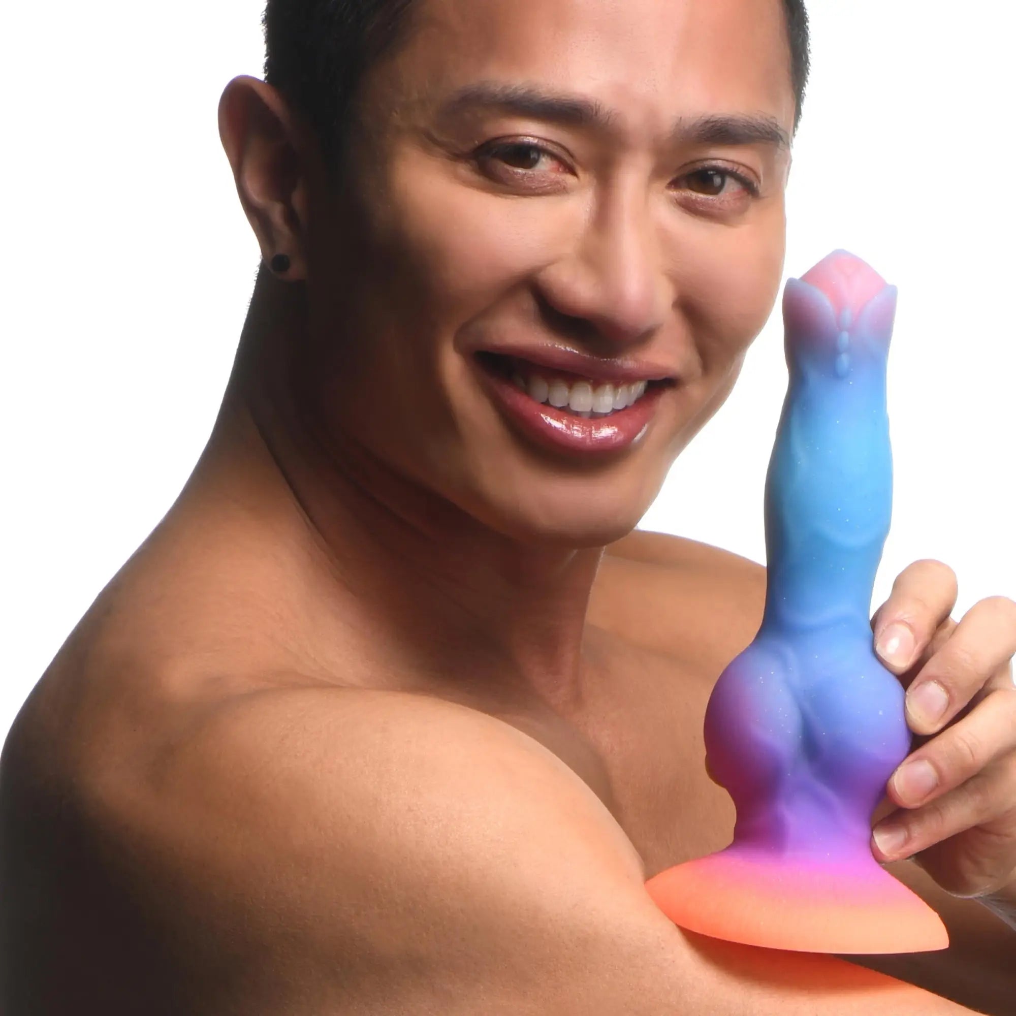 A man smiling and holding a blue, purple, and orange gradient Creature Cocks Space alien silicone dildo.