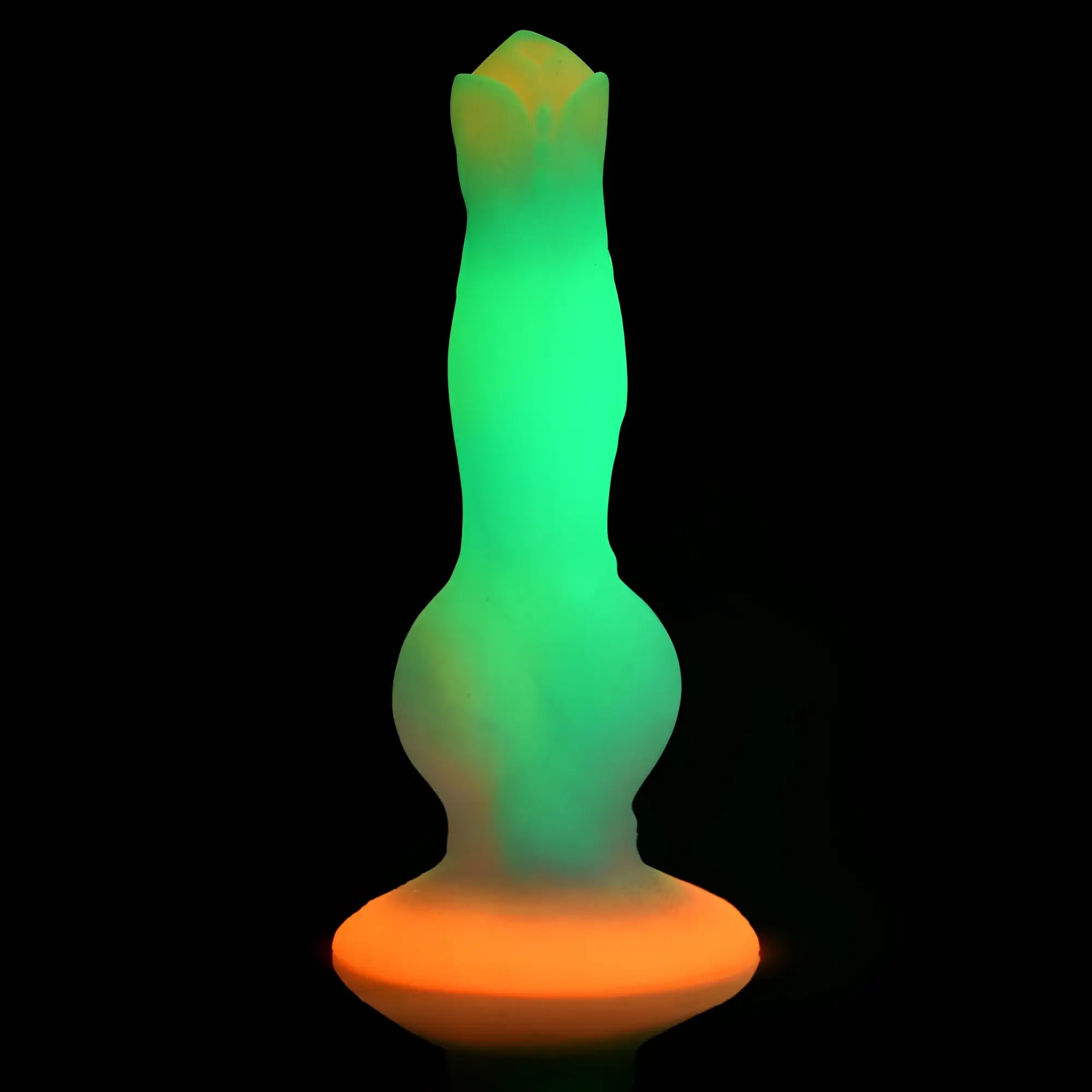 Creature Cocks Space Cock glow-in-the-dark silicone dildo with a green shaft and bright orange base against black.