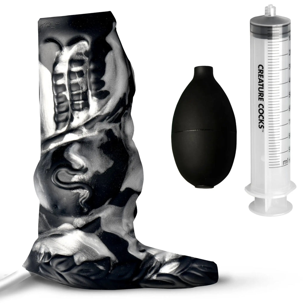 Creature Cocks silicone enhancer with marbled black and white texture, black bulb pump, and marked fluid syringe.
