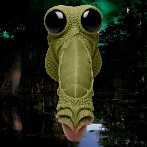 Creature Cocks Swamp Monster silicone dildo: green, scaly creature head with large black eyes, set against a swamp.