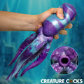 Creature Cocks Tenta Stroke: A purple and blue, octopus-shaped silicone masturbator held in hand, showing tentacle base.