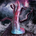 Creature Cocks silicone tentacle dildo in a red and blue gradient, featuring realistic suction cup texture on a rock.