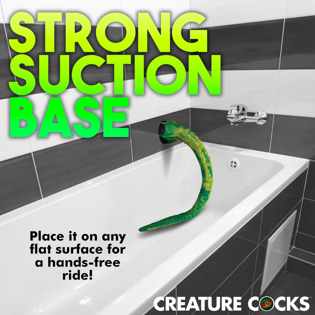 Creature Cocks Titan Tentacle dildo in green and yellow with a black suction base, mounted to a tiled bathtub wall.