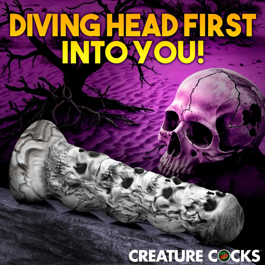 Creature Cocks Tower of Doom silicone dildo: a white and black marbled, skull-themed textured shaft on rocky ground.