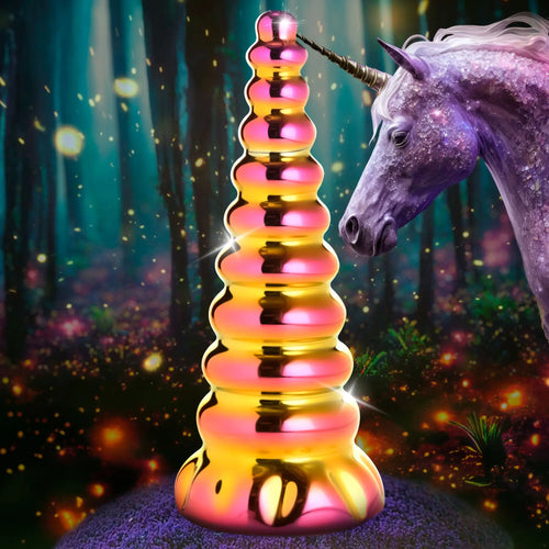 Creature Cocks Twilight Rainbow glass dildo with a ridged, iridescent gold-to-pink finish beside a magical unicorn.