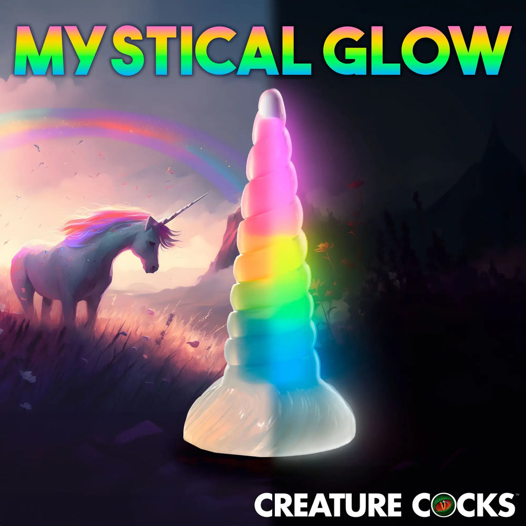 Creature Cocks Uni-Glow: a rainbow, glow-in-the-dark, spiral-textured unicorn horn dildo against a fantasy background.