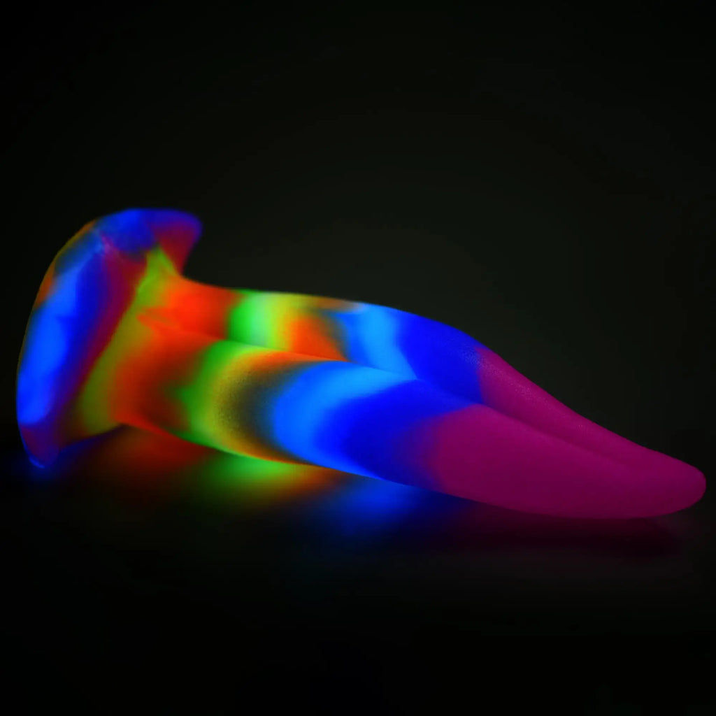 Creature Cocks Unicorn Kiss silicone dildo featuring a glowing, rainbow-swirled, bifurcated tongue shape.