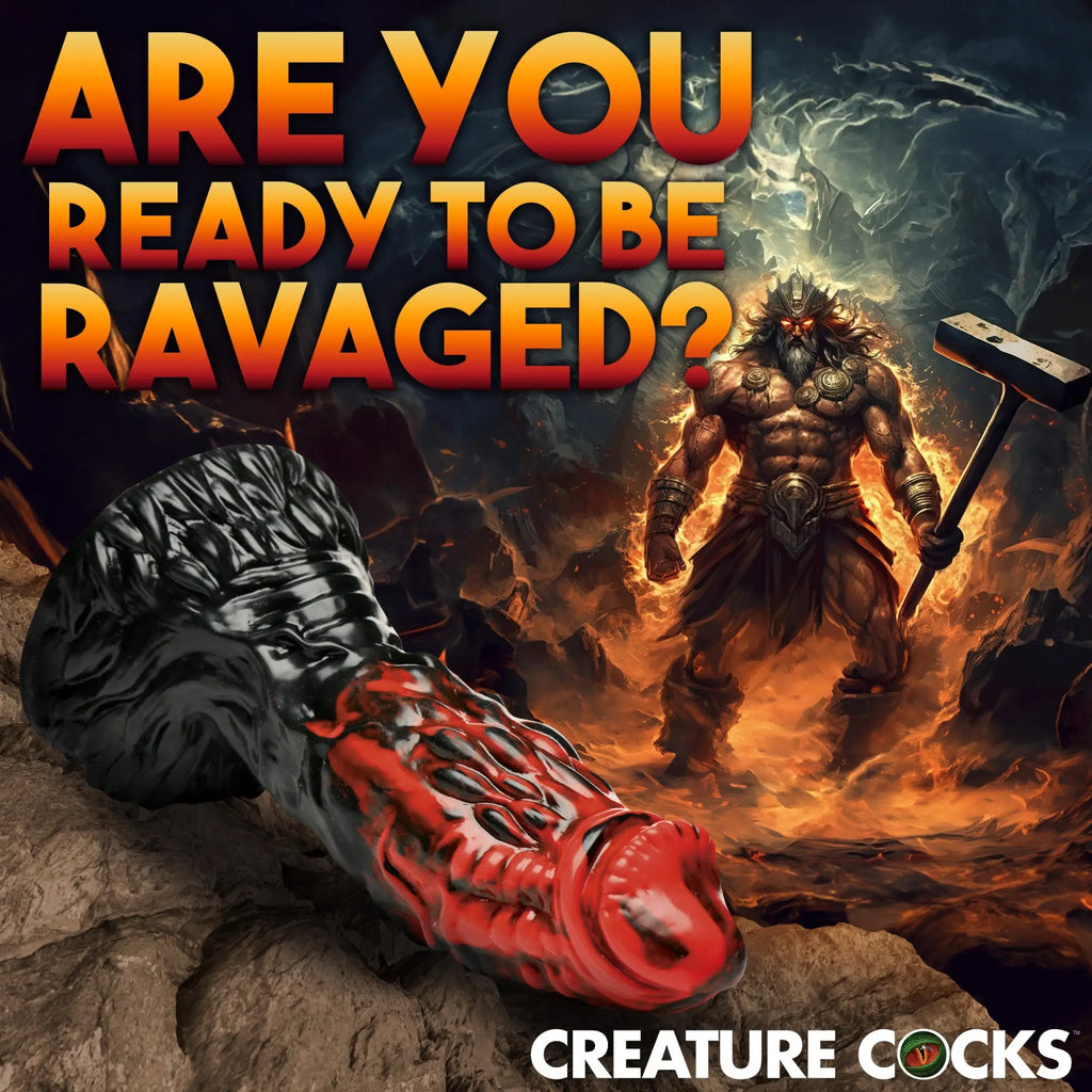 Creature Cocks Vulcan silicone dildo: a textured black and red fantasy-style dildo with a flared base on rocky ground.