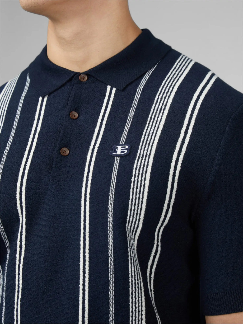 Navy blue and white vertically striped crinkle cotton polo shirt with small embroidered logo on the left chest